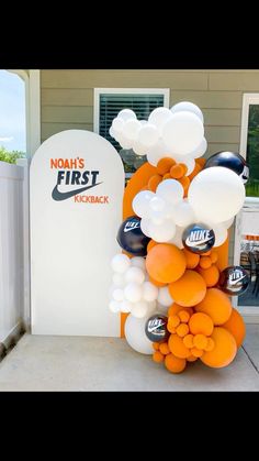 an orange and white balloon arch with the words noh's first kickback on it