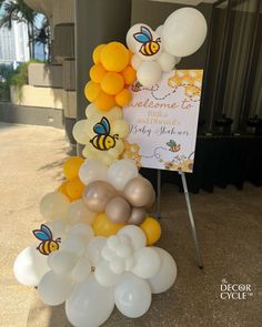 there is a sign that says welcome to the baby shower and balloons are all around it