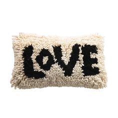 a black and white pillow with the word love embroidered on it's front side