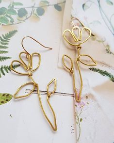 A  beautiful pair of hand shaped brass wire wild flower inspired earrings Based on a simple outline drawing I did of a wild flower, I used wire to replicate its lines and shapes.  These earrings are delicate, lightweight and so easy to wear They are made from gold brass wire, and are hung from gold plated french hooks They are minimalist and graceful The measure approximately 7cm from the top of the hook to the bottom of the stem Handmade Gold Flower Earrings For Spring, Whimsical Gold Wire Wrapped Earrings, Whimsical Gold Flower-shaped Earrings, Whimsical Gold Jewelry For Spring, Whimsical Spring Gold Jewelry, Spring Whimsical Gold Jewelry, Nature-inspired Gold Wire Wrapped Earrings, Nature-inspired Gold Flower Earrings With Ear Wire, Gold Whimsical Flower-shaped Earrings