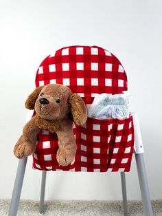 a teddy bear sitting in a red and white checkered chair with a cleaning cloth on it