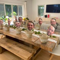 a group of men sitting at a table with baskets on it's heads and plants in front of them