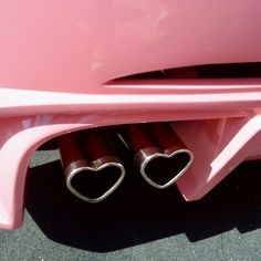 two heart shaped exhaust pipes in the trunk of a pink car