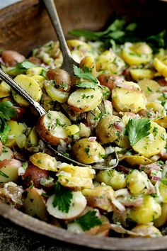 a wooden bowl filled with potatoes and parsley