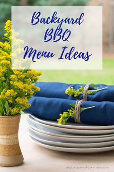 yellow flowers are in a vase next to plates and blue napkins