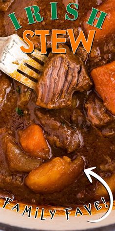 a bowl filled with stew and carrots next to a fork