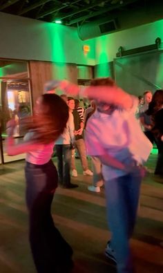 two people are dancing on the dance floor in front of a group of other people