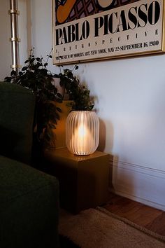 a lamp sitting on top of a table next to a green chair