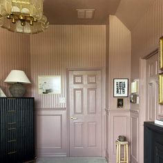 a bedroom with pink walls and gold trim on the door, carpeted floor and bed