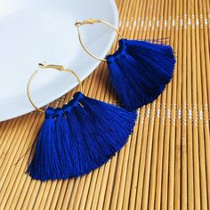 Enjoy the summer wearing these royal blue hoop tassel earrings. Inspired by tribal style, these fan earrings are supplied with a gold-toned hoop and have 5 mini tassels which are crafted using rayon threads. Lightweight and comfortable to wear, these statement earrings will be an eye-catching addition to everyday outfits as well as a evening look. These bright tassle earrings will catch all eyes. If you love bohemian or hippie-style accessories, these cobalt blue fringe earrings are the perfect finding for you. Length: 2.75'' (7 cm) Width: 2.75'' (7 cm) Hoops diameter: 1.3'' (3,3 cm) Materials:  - blue rayon threads - gold color accessories.  100% top quality handmade earrings If you have special size requirements, please send me a letter about it, as this can be made to order. Shipping ti Fan Earrings, Fringe Earrings, Style Accessories, Jewelry Earrings Hoops, Hippie Style, Tassel Earrings, Handmade Earrings, Cobalt Blue, Everyday Outfits