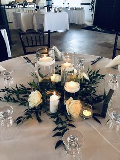 a table topped with lots of white flowers and candles