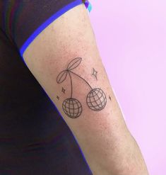 a woman's arm with a tattoo on it that has two balls in the middle