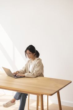 a woman sitting at a table using a laptop computer