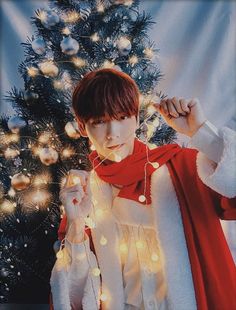 a person standing in front of a christmas tree