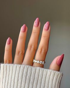 a woman's hand with pink manies and a diamond ring on it,