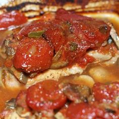 the meat is covered with tomatoes and mushrooms