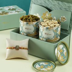 two tins filled with nuts sitting on top of a table next to a pillow