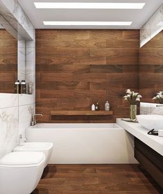 a modern bathroom with wood paneling and white fixtures