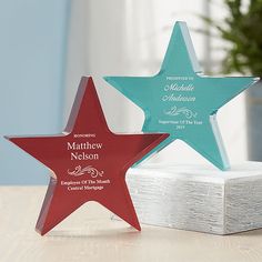 three star shaped award plaques on top of a table