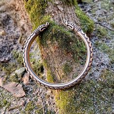 The Torc bracelet is made from flexible bronze solid by hand casting. The arm ring made with Norse dragon heads like on ancient viking artifacts. The bracelet can be used as arm cuff or oath ring, or viking cosplay. The Torc is resizable so it can fit a mens or womens bracelet. Also it`s a perfect option for gifts for people who likes Celtic, Norse, Viking or Nordic jewelry. Bracelet base thickness: 7 mm | 1/4 inch Average weight: 70 grams | 2.5 oz Other items in my shop: https://etsy.me/2YZKfPZ Bronze Viking Jewelry For Ceremonial Occasions, Viking Style Metal Bracelet Jewelry, Heathen Wedding, Torc Bracelet, Norse Dragon, Viking Arm Rings, Viking Artifacts, Viking Aesthetic, Nordic Jewelry