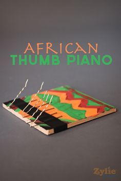 the cover of african thump piano, which is made out of wood and has green lettering on