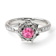 a white gold ring with a pink stone in the center and diamond accents around it