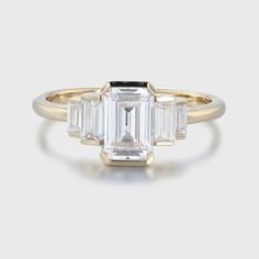 an emerald cut diamond ring with three baguets