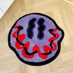 a purple rug with red and black designs on the floor next to a white door