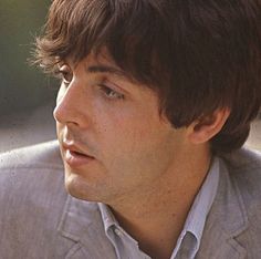 a close up of a person wearing a suit and tie looking off to the side