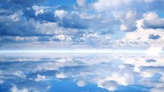 the sky and clouds are reflected in the water