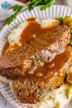 meatloaf with gravy and mashed potatoes on a paper plate