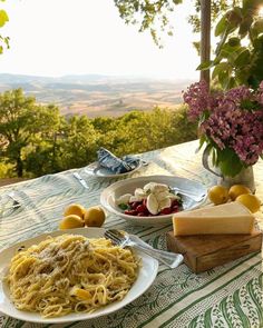 a table topped with plates of pasta and cheese