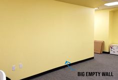 an empty office room with yellow walls and black border around the area where it is located