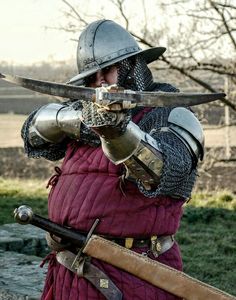 a man dressed in armor holding two swords