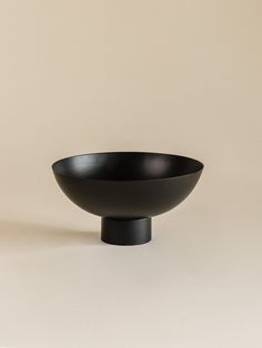 a black bowl sitting on top of a white table