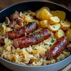 two sausages, potatoes and sauerkraut in a bowl on a wooden table