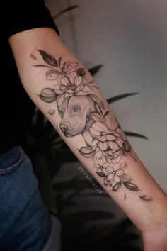 a woman's arm with flowers and a goat tattoo on the left side of her arm