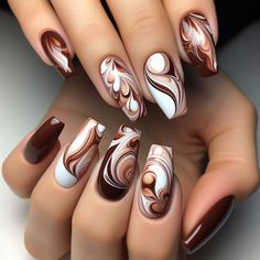 The nails are adorned with a delicious-looking water marble design in shades of rich brown and creamy white. The colors blend in a way that mimics the look of swirled chocolate and cream, creating a sweet and indulgent effect. This design is perfect for those who love a unique and appetizing manicure. Nail Art In Brown Color, Fall Nail Art Designs Almond Shape, Fall Color Design Nails, Cocoa Nails Design, Fall Nail Ideas Brown, White And Brown Marble Nails, Coffee Swirl Nails, Fall Marble Nail Designs, Chocolate Nails Design