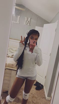 a woman taking a selfie in the mirror with her leg up and socks on