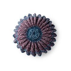 a crocheted flower on a white background with blue and pink petals in the center