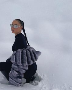 a woman is sitting in the snow with her skis on