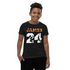 a young boy wearing a black shirt with the number 24 on it