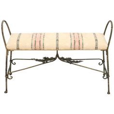 a metal bench with a striped cushion on it's back and arms, sitting against a white background