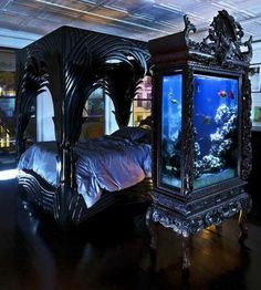 a bed with an aquarium on top of it in the middle of a dark room