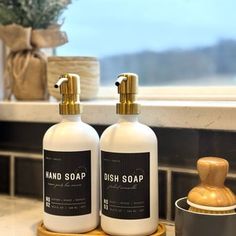 two soap dispensers sitting on top of a counter