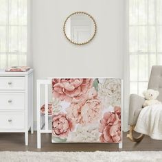 a baby's room with white furniture and pink flowers