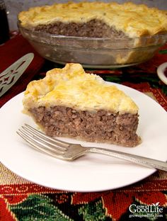 a piece of pie sitting on top of a white plate next to a knife and fork