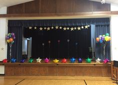 balloons and stars are on display in front of the stage