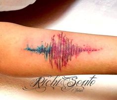 a colorful sound wave tattoo on the arm