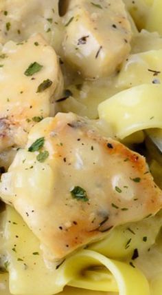 a close up of chicken and noodles on a plate with a fork in the bowl